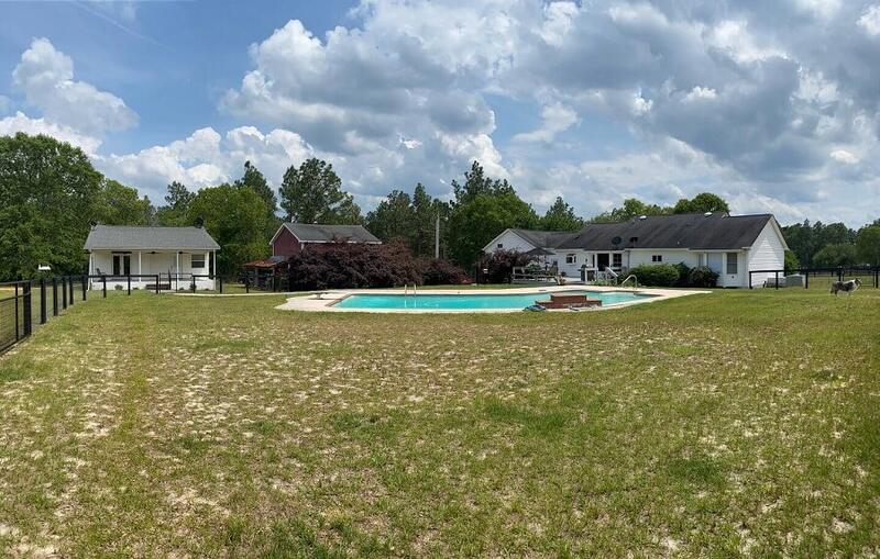 The backyard of Dreamcatcher Farm with private rental cottage and in-ground pool next to the owner's house.